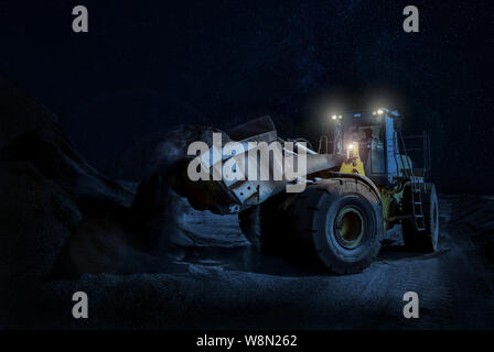 Mining caricatore su ruote di movimentazione sulla ghiaia una notte tempo progetto di costruzione Foto Stock