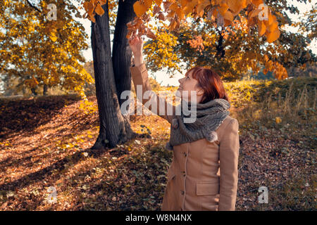 Allegro giovane donna redhead godendo in posizione di parcheggio Foto Stock