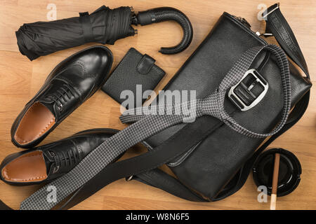 Bella black classic uomo accessori, valigetta in pelle, cinghia, cravatta e scarpe. Vista dall'alto. Foto Stock