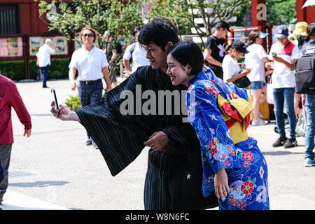 Tokyo, Giappone. 10 Ago, 2019. Un giovane in uno yukata (un informale estate kimono) prende selfie presso il tempio Sensoji di Asakusa, Tokyo. Credito: Keith Tsuji/ZUMA filo/Alamy Live News Foto Stock