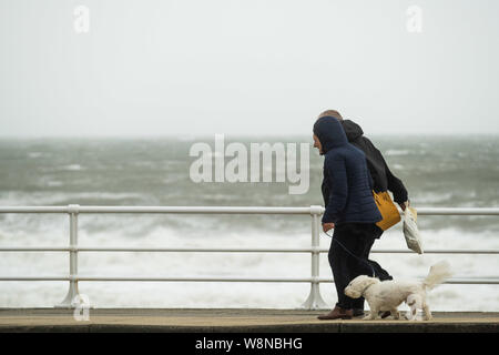 10 ago 2019 Aberystwyth Wales UK. Regno Unito: Meteo gale force vento con raffiche fino a oltre 50km/h e il mare in tempesta pastella il faro del porto, e rende la vita difficile per i pedoni in Aberystwyth come unseasonably bagnato e ventoso spazia su gran parte dell'ovest del Regno Unito , portando gravi perturbazioni per viaggiare e forzare la cancellazione di molti eventi all'esterno. Credito foto Keith Morris/Alamy Live News Foto Stock