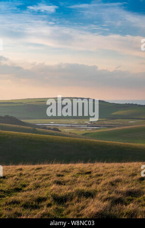 Cercando su dolci colline a Cuckmere Valley e Seaford in serata calda luce 2 Foto Stock