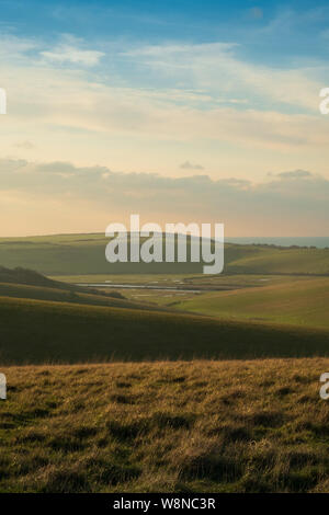 Cercando su dolci colline a Cuckmere Valley e Seaford in serata calda luce 1 Foto Stock