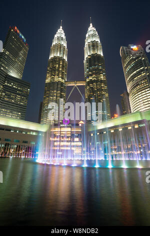 Petronas Twin Towers al crepuscolo con fontana colorata Foto Stock