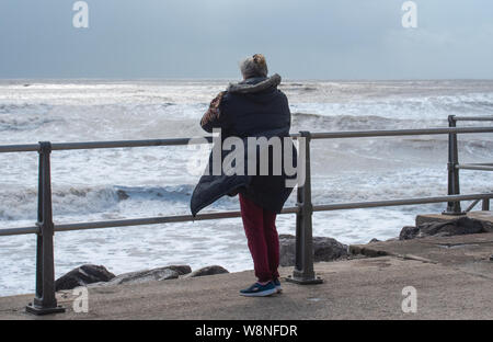 Charmouth, Dorset, Regno Unito. Il 10 agosto 2019. Meteo REGNO UNITO: vacanzieri avventurarvi in un blustery giornata al villaggio sul mare di Charmouth come unseasonably strong a sud-ovest si snoda continuano ad impasto lungo la costa sud occidentale il sabato pomeriggio. Warmings giallo per il vento ad alta velocità sono stati rilasciati attraverso il Sud Ovest. Credito: Celia McMahon/Alamy Live News. Foto Stock