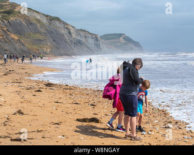 Charmouth, Dorset, Regno Unito. Il 10 agosto 2019. Meteo REGNO UNITO: vacanzieri avventurarvi in un blustery giornata al villaggio sul mare di Charmouth come unseasonably strong a sud-ovest si snoda continuano ad impasto lungo la costa sud occidentale il sabato pomeriggio. Le condizioni tempestose non scoraggiare i cacciatori di fossili sulla spiaggia Charmouth. Credito: Celia McMahon/Alamy Live News. Foto Stock