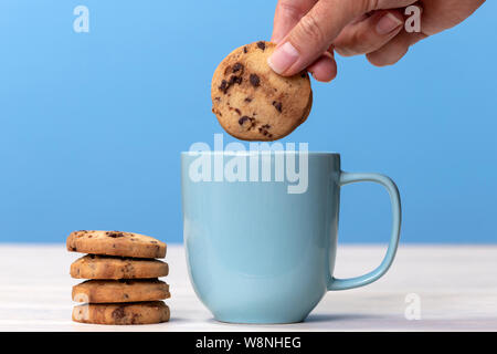 Dunking un biscotto in una tazza di tè Foto Stock