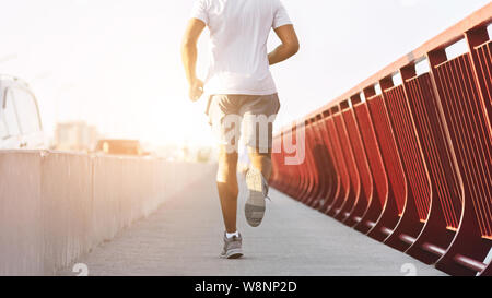 Immagine ritagliata di afro sportivo uomo che corre sul ponte Foto Stock