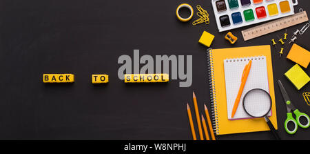 Colorato in giallo forniture scolastiche con il ritorno a scuola il testo Foto Stock