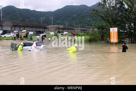 Taizhou , Cina. 10 Agosto, 2019. (190810) -- TAIZHOU, il 10 agosto 2019 (Xinhua) -- funzionari di polizia stradale spostare un diluvio di filamento in auto Luqiao distretto della città di Taizhou, est della Cina di Provincia dello Zhejiang, il 10 agosto 2019. Typhoon Lekima, nono di l'anno, fatta approdo di sabato in Wenling City. Il salvataggio e il clean-up le opere sono state eseguite in tutte le parti della provincia di Zhejiang. (Foto di Jiang Youqin/Xinhua) Credito: Xinhua/Alamy Live News Foto Stock