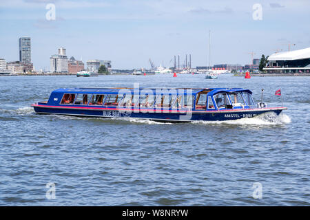 Amsterdam canal boat AMSTEL-ROBIJN di blu spedizione in barca sull'IJ nelle vicinanze della stazione centrale. Foto Stock