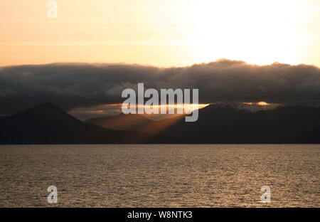 Raggi di sole rompere attraverso le nuvole Foto Stock