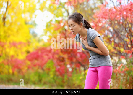 Esecuzione di nausea - nausea e mal malati runner vomito. Esecuzione di sentimento donna male circa a vomitare. Ragazza avente nausea dalla disidratazione o dolore al petto. Foto Stock