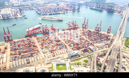 Porto di Hong Kong il distretto industriale con il contenitore di carico nave, gru, auto il traffico su strada e ponte Stonecutters Bridge. Logistica il concetto di settore Foto Stock