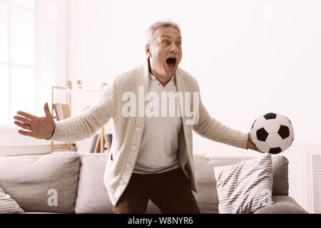 Emotional uomo maturo guardando la partita di calcio in televisione Foto Stock