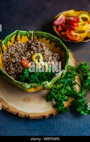 Dieta cheto concetto con bolliti di semi di grano saraceno e verdure in una ciotola rustico in pietra con sfondo copyspace Foto Stock