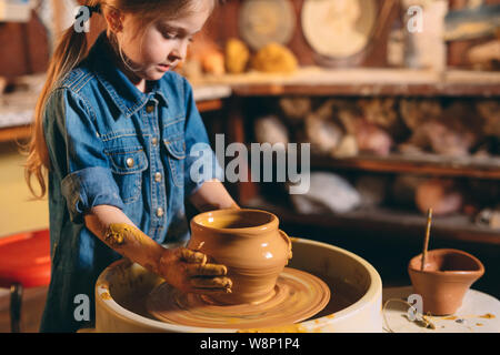 Laboratorio di ceramica. Una bambina fa un vaso di creta. La modellazione di argilla Foto Stock