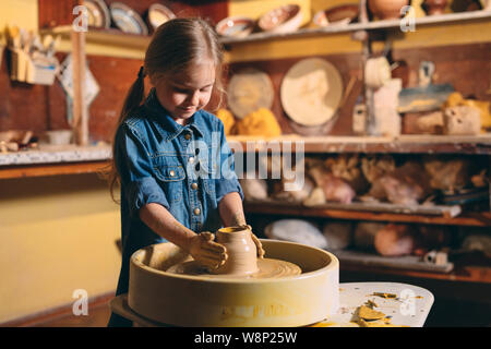 Laboratorio di ceramica. Una bambina fa un vaso di creta. La modellazione di argilla Foto Stock