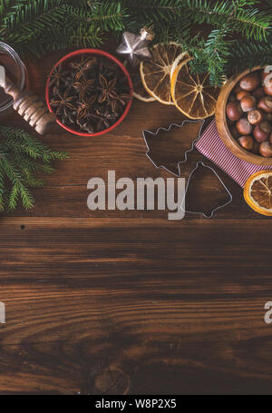 Natale il concetto di cottura con la farina, lo zucchero di canna, dadi, cannella e anice stella su sfondo di legno Foto Stock