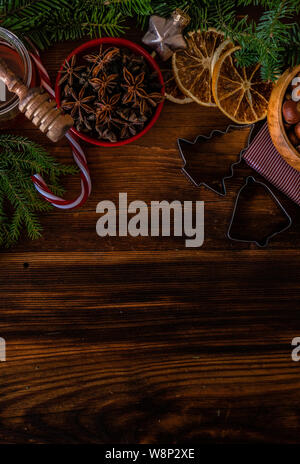 Natale il concetto di cottura con la farina, lo zucchero di canna, dadi, cannella e anice stella su sfondo di legno Foto Stock