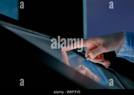 Donna con display touchscreen interattivo al moderno museo di storia Foto Stock