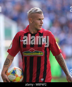 Magdeburg, Germania. 10 Ago, 2019. Calcio: DFB Cup, 1FC Magdeburg - SC Freiburg, 1° round in MDCC Arena. Freiburg's Jonathan Schmid è sull'erba. Credito: Peter Steffen/dpa - NOTA IMPORTANTE: In conformità con i requisiti del DFL Deutsche Fußball Liga o la DFB Deutscher Fußball-Bund, è vietato utilizzare o hanno utilizzato fotografie scattate allo stadio e/o la partita in forma di sequenza di immagini e/o video-come sequenze di foto./dpa/Alamy Live News Foto Stock