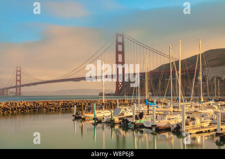 Barche a vela ormeggiata al Porto di Fort Baker, con il Golden Gate Bridge in background, al tramonto, Sausalito, California, Stati Uniti. Foto Stock