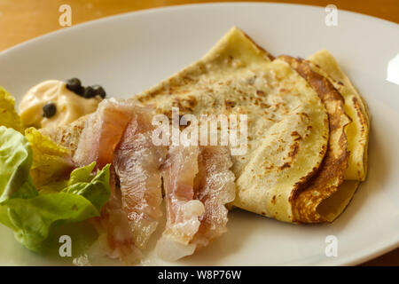 Gravlax con pancake servita foglie di insalata Foto Stock