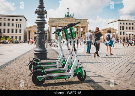 Berlino, Germania - Giugno, 2019: elettrica e scooter , escooter o e-scooter della società calce parcheggiato presso la Porta di Brandeburgo a Berlino Foto Stock