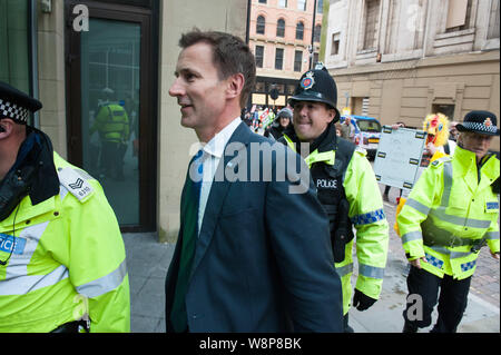 Manchester, Regno Unito. Il 7 ottobre 2015. Il segretario della Sanità Jeremy Hunt ha dovuto essere scortati dalla polizia come arrabbiato anti-austerità e anti-fracking protester Foto Stock