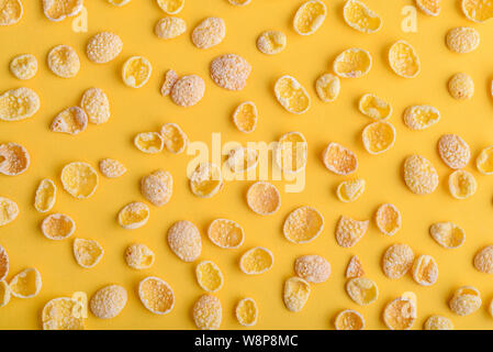 Fiocchi di mais modello su sfondo giallo, vista dall'alto Foto Stock