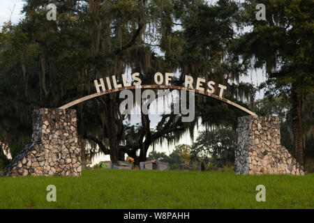 L'ingresso di un vecchio cimitero con lapidi e alberi di quercia drappeggiati in muschio Spagnolo in Florida Foto Stock