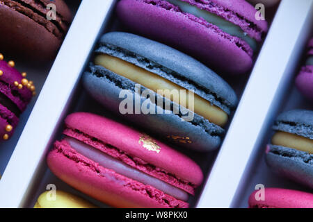 Assortimento di amaretto multicolore diversi si trovano nella scatola di cartone con la vista superiore Foto Stock