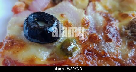 Close up di oliva nera su una pizza Foto Stock