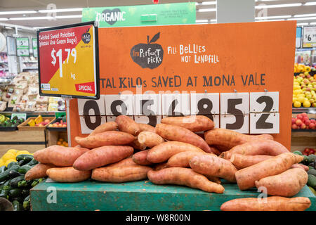 Imperfetta patate dolci sul prezzo ridotto a un supermercato di Sydney negozio di alimentari con display che mostra quanti kg sono state salvate dalla discarica Foto Stock