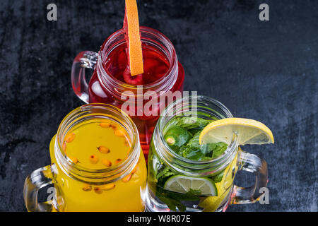 Limonata o cocktail mojito con limone e menta, lampone, bacche di olivello spinoso, pompelmo, freddo bevanda rinfrescante o bevande con ghiaccio. Foto Stock