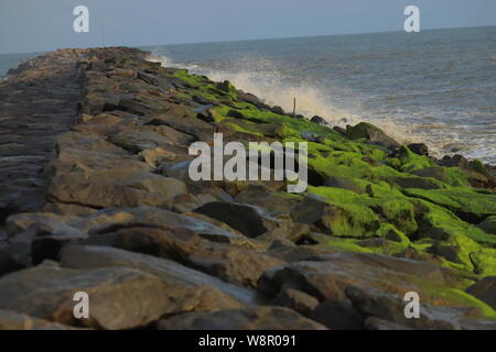 Le grandi rocce sotto forma di una linea verso il mare Foto Stock