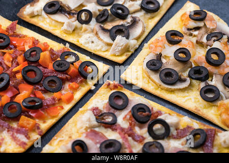 Un assortimento di fette di pizza. Margherita, salsiccia per pizza, quattro formaggi pizza. Vista dall'alto. Diversi tipi di pizza sul textured vecchio tavolo in legno Foto Stock