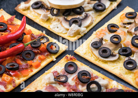 Un assortimento di fette di pizza. Margherita, salsiccia per pizza, quattro formaggi pizza. Vista dall'alto. Diversi tipi di pizza sul textured vecchio tavolo in legno Foto Stock