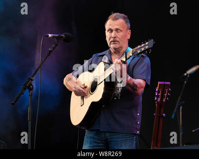 Martin Stewart Simpson, English folk cantante, chitarrista e cantautore e nove volte vincitore della BBC Radio 2 Folk Awards, artista dell'anno si esibisce dal vivo sul palco della convenzione di Fairport durante il Festival di Cropredy in Banbury. Foto Stock