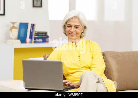 Senior Donna al lavoro su un notebook Foto Stock