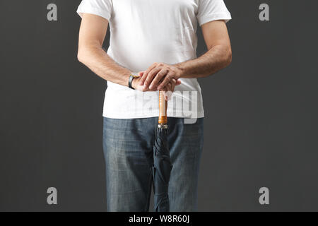 Midsection view of an old man holding umbrella Stock Photo