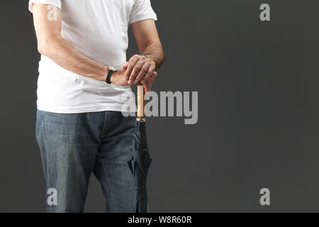 Sezione centrale di un vecchio uomo che tiene un ombrello Foto Stock