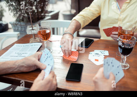 L'uomo prendendo a carte mentre il gioco d'azzardo con vecchi amici Foto Stock