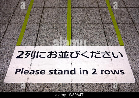 Tokyo / Giappone - 31 Luglio 2019: Segno sulla metropolitana di Tokio il pavimento della piattaforma di istruire i passeggeri di linea fino a 2 righe Foto Stock