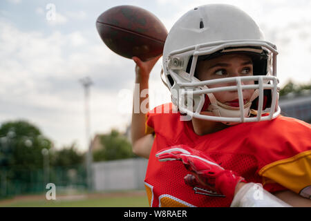 Foto del giocatore di football americano donna gettando la sfera Foto Stock