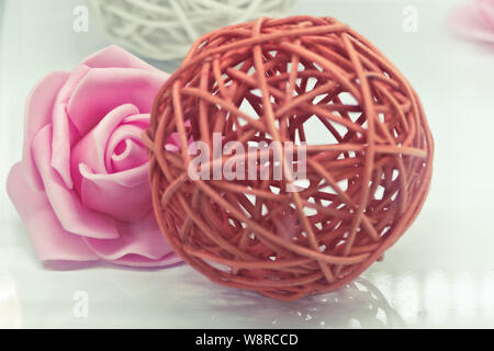 Sfera di rattan e materiale sul fiore bianco, instant photo look Foto Stock