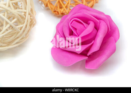 Sfera di rattan e fiore di materiale su bianco Foto Stock