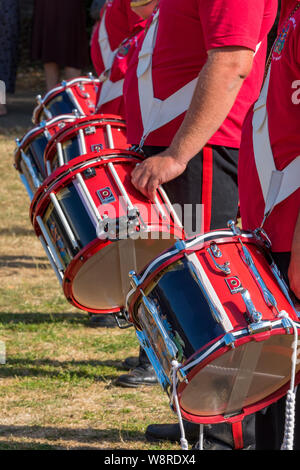 Una fila o una fila di batteristi in una band militare in parata in uniformi intelligenti. Foto Stock