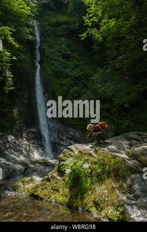 Giovane fotografo di scattare le foto con lo smartphone nella foresta Foto Stock